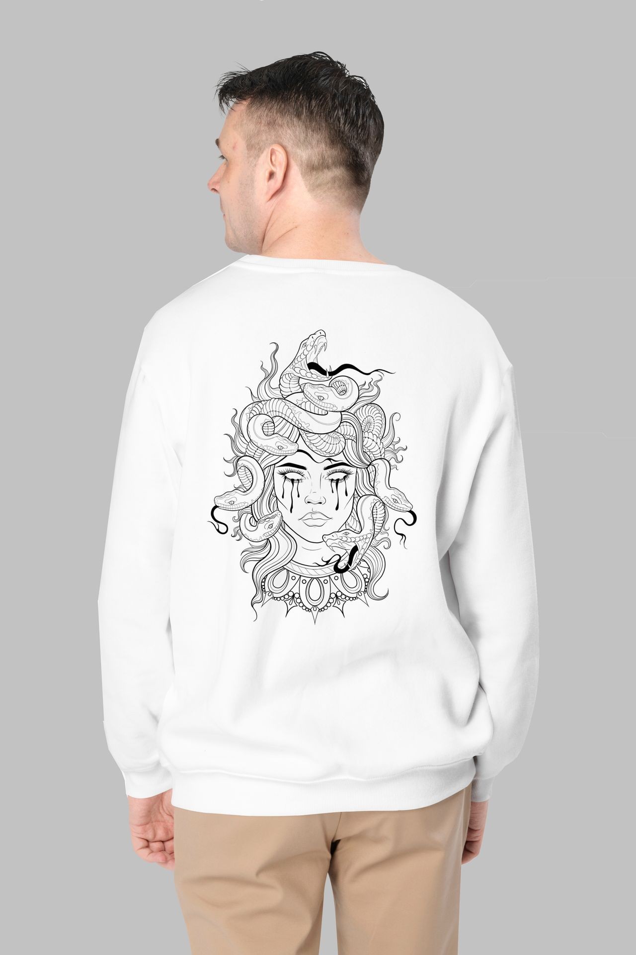 Person wearing a white sweatshirt with a black line-art dragon design on the back.