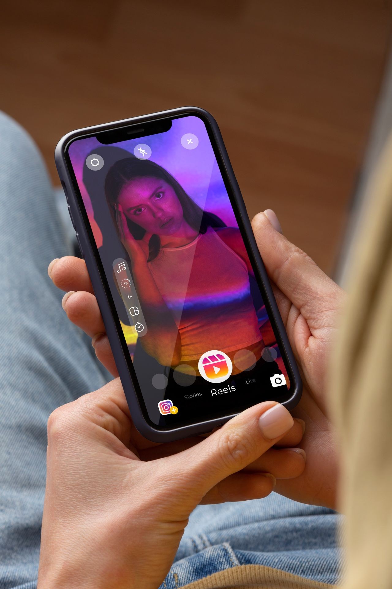 Person holding a smartphone displaying an Instagram Reel preview with vibrant colors and editing tools visible.