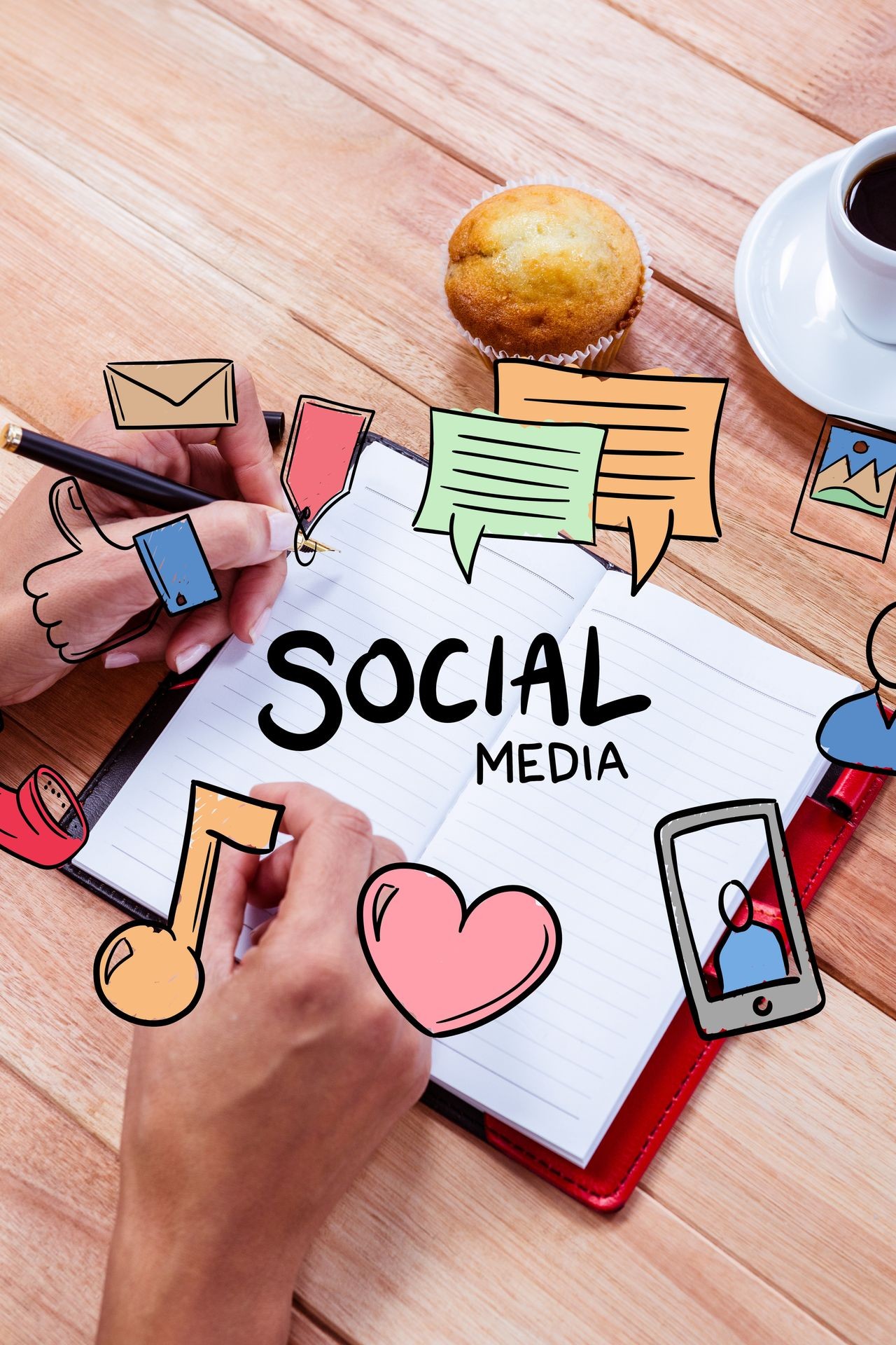 Person writing in notebook with social media icons and a muffin on the table.